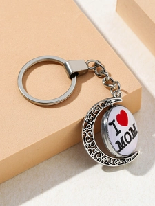 Detailed close-up of crescent moon keychain with I Love Mom rotating pendant on a block