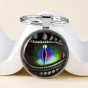 Macro shot of glass dragon eye keychain with colorful pupil and silver alloy keyring