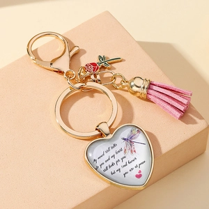Detail of a heart glass pendant keychain with pink tassel and red rose charm