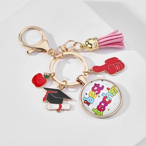 Detail of keychain with pink tassel, red apple charm and best teacher glass pendant