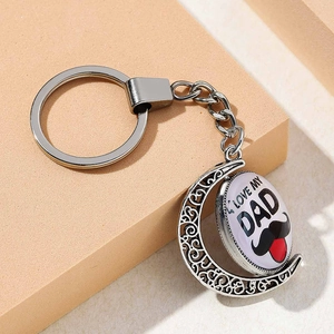 Macro view of silver rotating crescent moon keychain with I LOVE MY DAD engraving