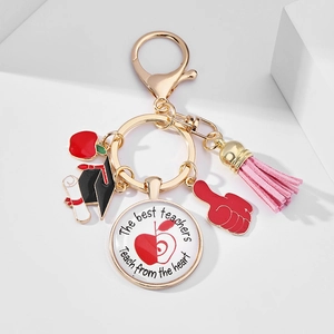 Detail of teacher appreciation keychain with red apple, graduation cap and pink tassel