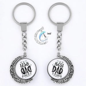 Detail of silver moon keychain with rotating glass pendant showing Best Dad message