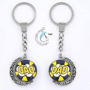 Close-up of a rotating moon pendant keychain with blue DAD artwork on a glass gem