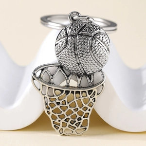 Porte-clés panier de basket en métal argenté poli avec ballon texturé sur support blanc