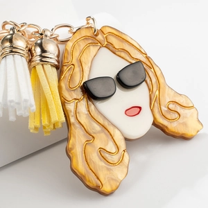 Porte-clés visage de fille en acrylique avec pompons colorés et chaîne dorée