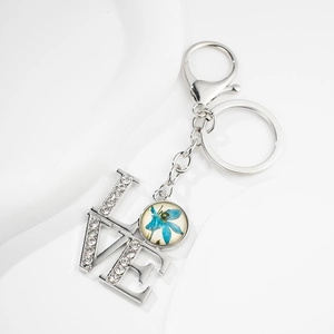 Detailed view of silver LOVE keychain with sparkling rhinestones and blue floral charm
