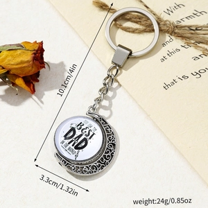 Silver Father's Day keychain with rotating Best Dad moon charm on rustic background