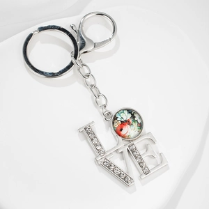 Silver love keychain with rhinestone letters and floral pendant on white background