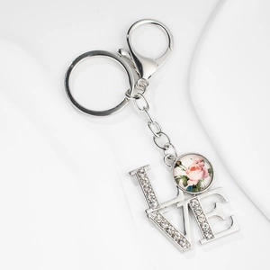 Détail du porte-clés LOVE serti de strass avec pendentif rose rétro et fermoir mousqueton