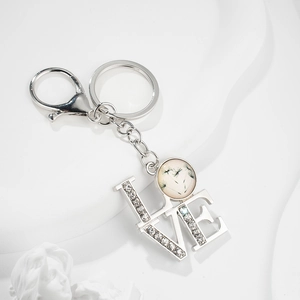 Silver LOVE keychain with sparkling rhinestones and a dandelion glass charm on white base