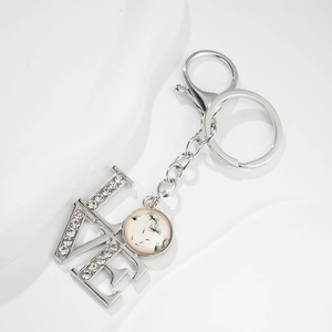 Detail of silver LOVE keychain with inlaid rhinestones and dandelion glass pendant