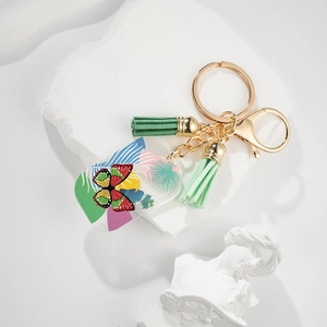 Detail of tropical butterfly keychain with green tassels and golden lobster clasp