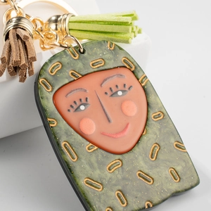 Artistic keychain with green resin pendant, face painting and dual colored tassels