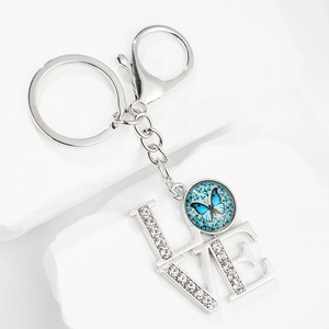 Silver metal LOVE keychain with sparkling crystals and blue butterfly glass cabochon
