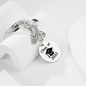 Gros plan du porte-clés Promo 2023 avec pendentifs hibou et petite fleur d'acier