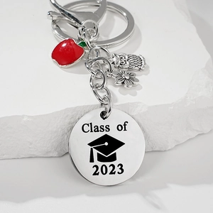 Détail du porte-clés de remise des diplômes avec breloques pomme et gravure Class of 2023