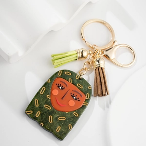 Detail of creative girl pendant keychain with green floral scarf and suede tassels