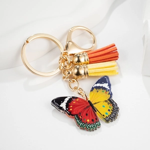 Gros plan détaillé du porte-clés papillon coloré avec glands en cuir et fermoir doré brillant