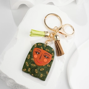 Creative green resin face keychain with gold patterns and stylish leather tassels