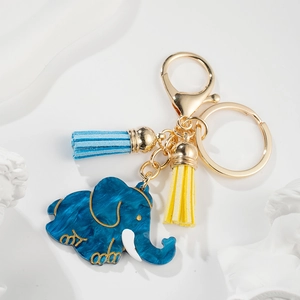 Artistic close-up of dark blue elephant charm with gold accents and soft colorful tassels