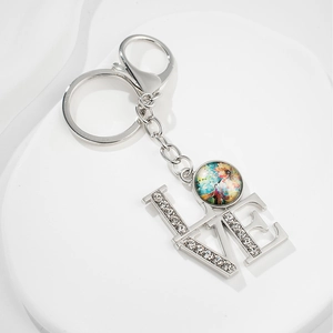 Detailed close-up of a silver LOVE keychain featuring sparkling rhinestones and a colorful pendant