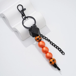 Detail of handmade wooden bead keychain with orange and black checkered patterns