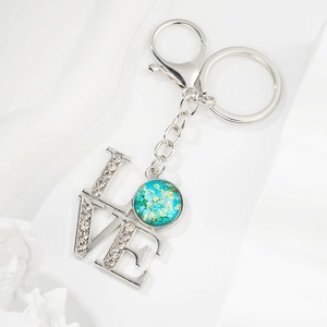 Detailed close-up of LOVE silver keychain with crystals and Van Gogh art pendant