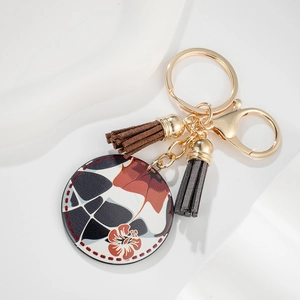 Detail of geometric tortoise pendant with leather tassels and gold lobster clasp keychain