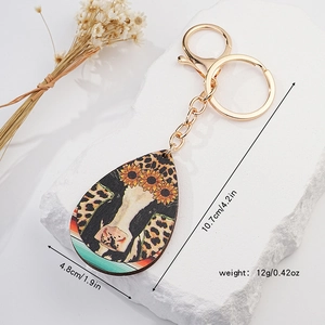 Teardrop western keychain with sunflower and cow print patterns, including size details