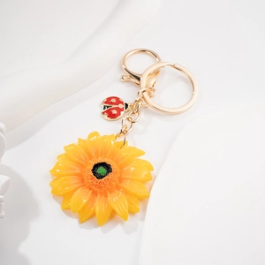Dettaglio portachiavi girasole con petali in resina e ciondolo a forma di coccinella