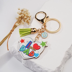 Detail of I love you DAD heart keychain with green tassel and gold keyring on stone