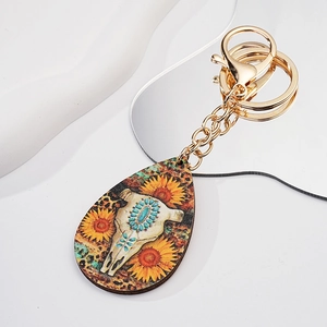 Western bull skull and sunflower pattern on a teardrop wooden keychain with gold ring