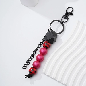 Detail of red buffalo plaid and pink matte wooden beads on a stylish car keychain accessory