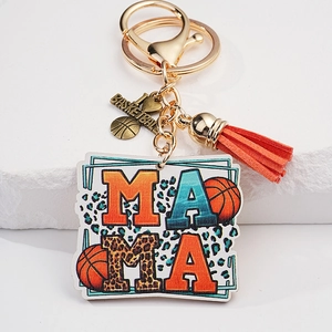 Detail of mama basketball keychain with golden lobster clasp and vibrant orange tassel