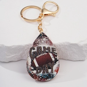 Dettaglio portachiavi a goccia con motivo football e scritta Game Day in stile leopardato