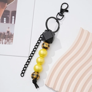Handmade wooden bead keychain with yellow and black patterned beads and black metal clasp