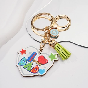 Close-up of heart-shaped wooden keychain with I love you DAD print and green tassel
