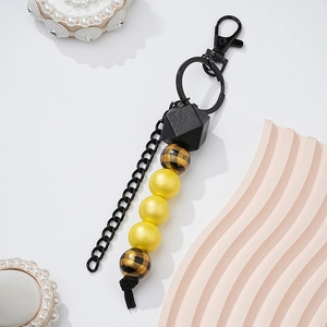 Detail of wooden beaded keychain with leopard pattern beads and black metal hook clasp