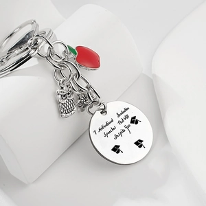 Vue macro porte-clés enseignant en acier avec breloques pomme rouge et hibou