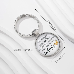 Macro shot of silver metal keychain with butterfly pendant and inspirational quote