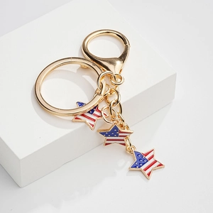 Golden American flag star pendant keychain with lobster clasp on white platform