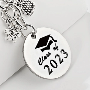 Détail du porte-clés enseignant en acier avec breloques de remise de diplôme hibou et fleur