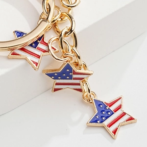 Close-up of golden metal keychains featuring three American flag star charms