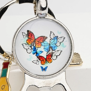 Detail of vintage metal butterfly keychain with glass gem and beer bottle opener function