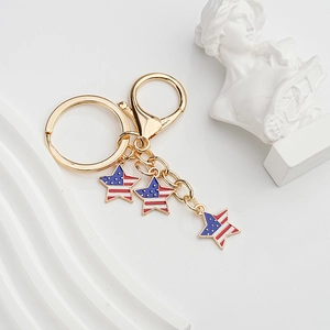 Detailed close-up of American flag star charms on a gold metal keychain with lobster clasp