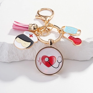 Détail d'un porte-clés médical doré avec gland rose et pendentif cœur et stéthoscope
