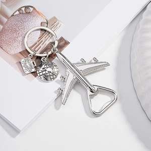 Detail eines Flugzeug Flaschenöffners mit Koffer Anhänger und kleinem Globus