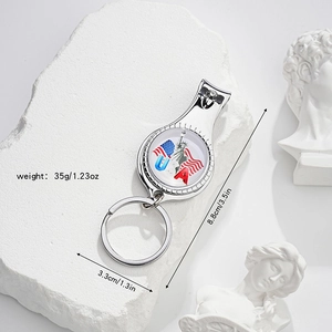 Macro view of multifunctional USA flag nail clipper keychain with dimensions on stone surface