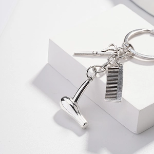 Creative barber set keychain featuring mini hair dryer, comb, and scissors on a metal ring